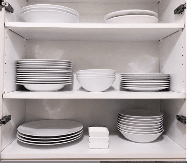 clean white dishes in a cabinet