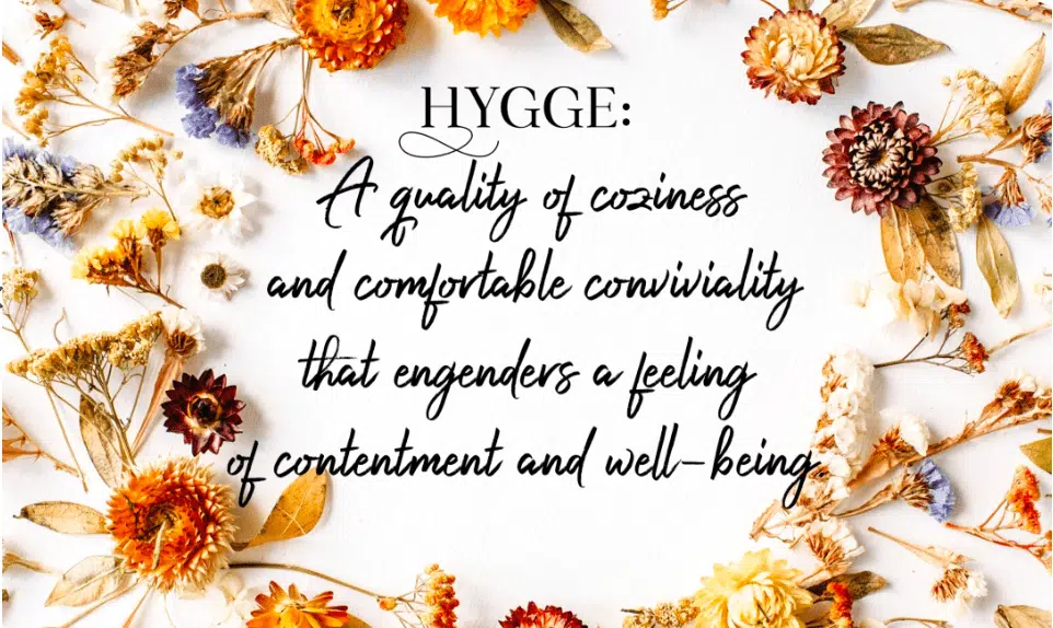 the definition of hygge on a floral wreath background
