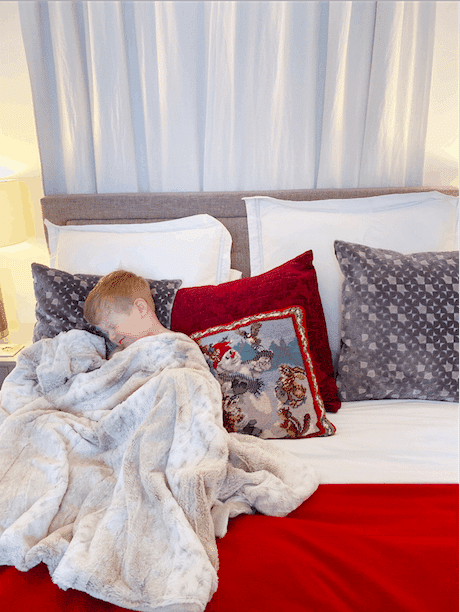 a small boy in a Christmas decorated bed