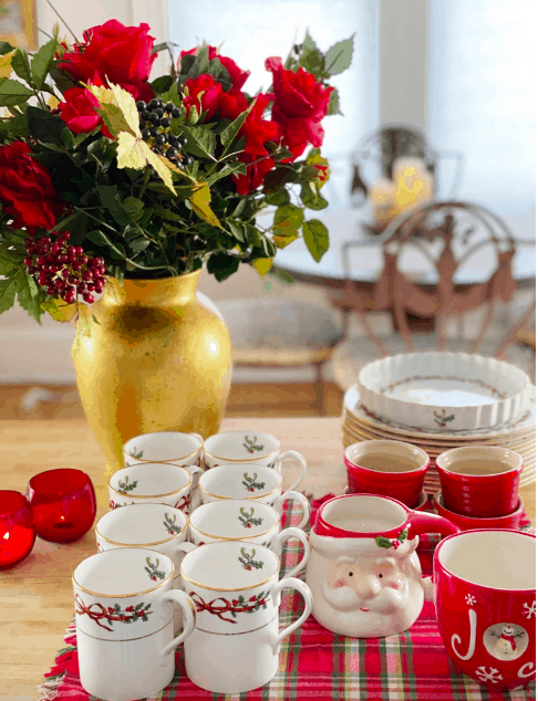 a holiday table set with dishes and flowers