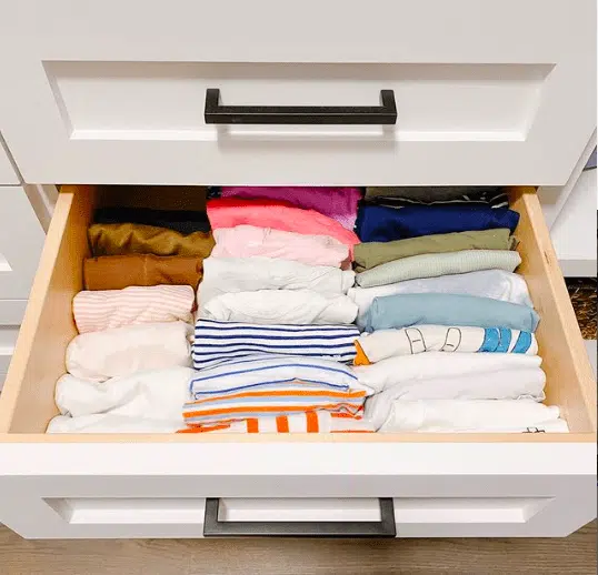 An organized drawer of file folded t-shirts