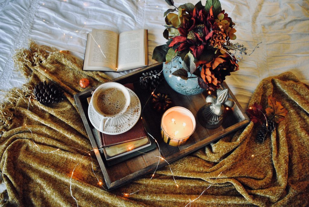 a tray with a cup of coffee and fairy lights and a candle