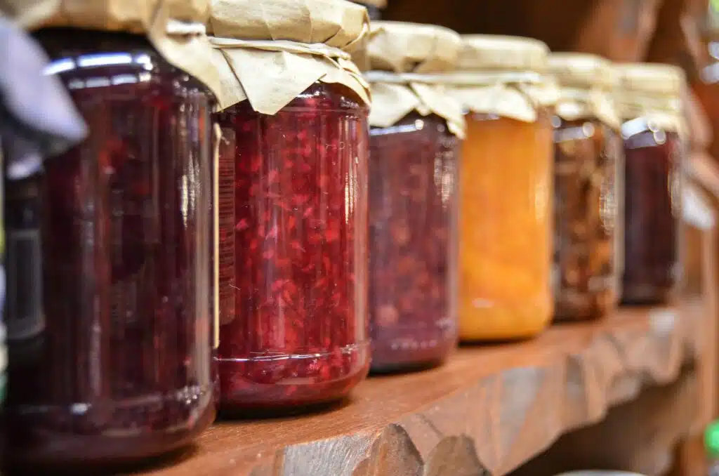 clear glass jars full of colorful fruit jams