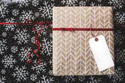 gift box with brown wrapping paper on black snowflake material