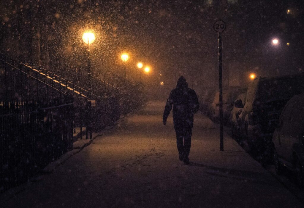 man walking on city street in winter